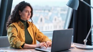 Woman in an office practicing SEO content writing by a laptop