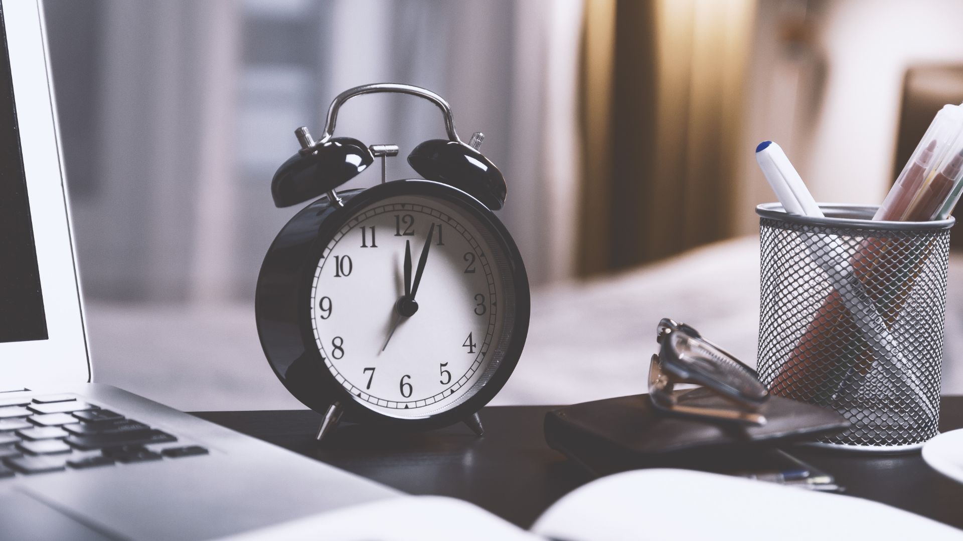 Clock on a desk next to a laptop symbolizing dwell time in SEO