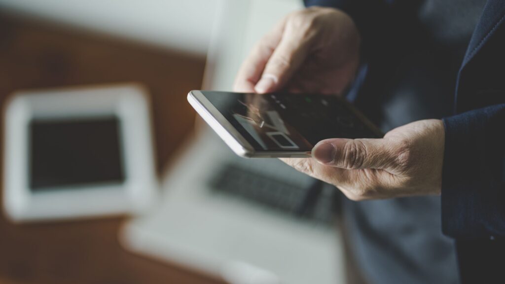 Man in suit watching YouTube video on smartphone