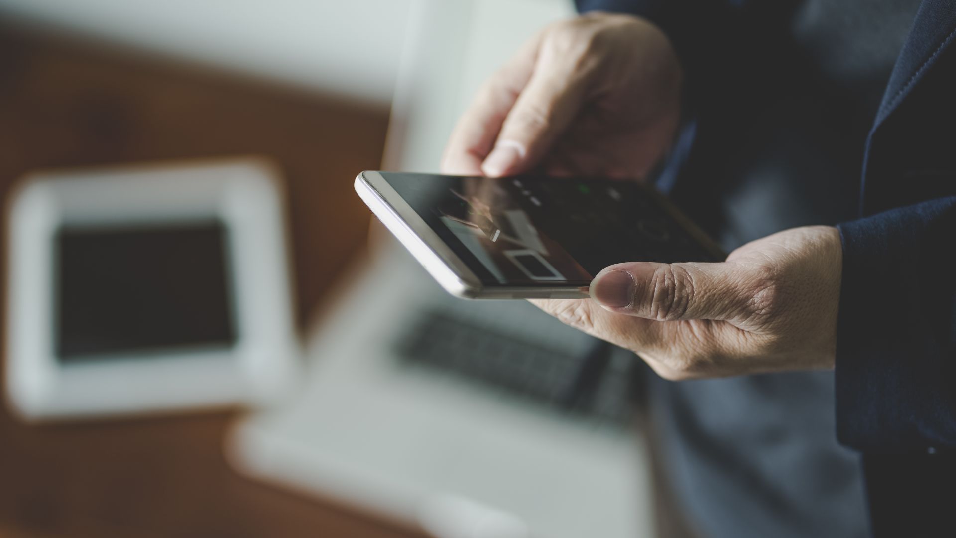 Man in suit watching YouTube video on smartphone