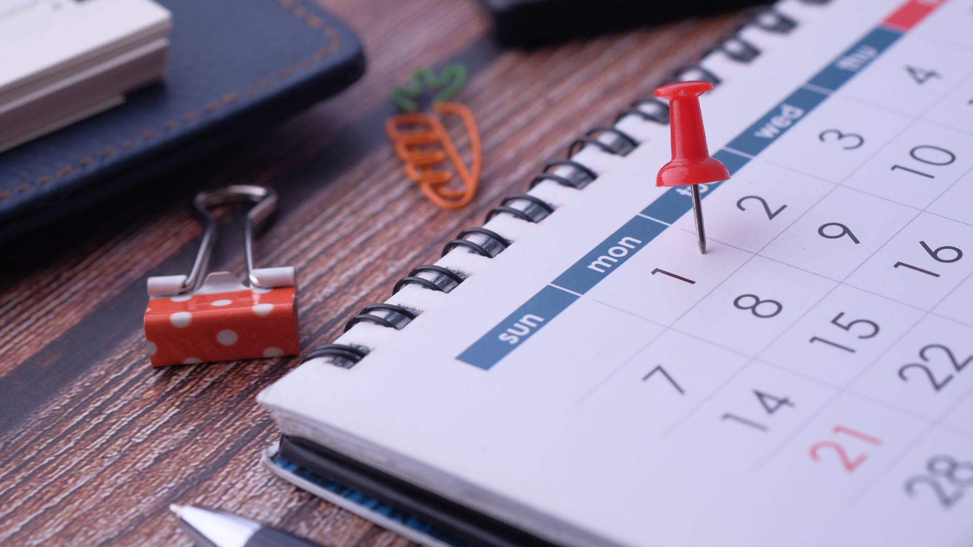 A content calendar with a pin in it on a desk.