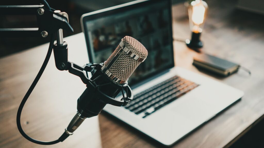 A podcast studio containing a microphone and a laptop