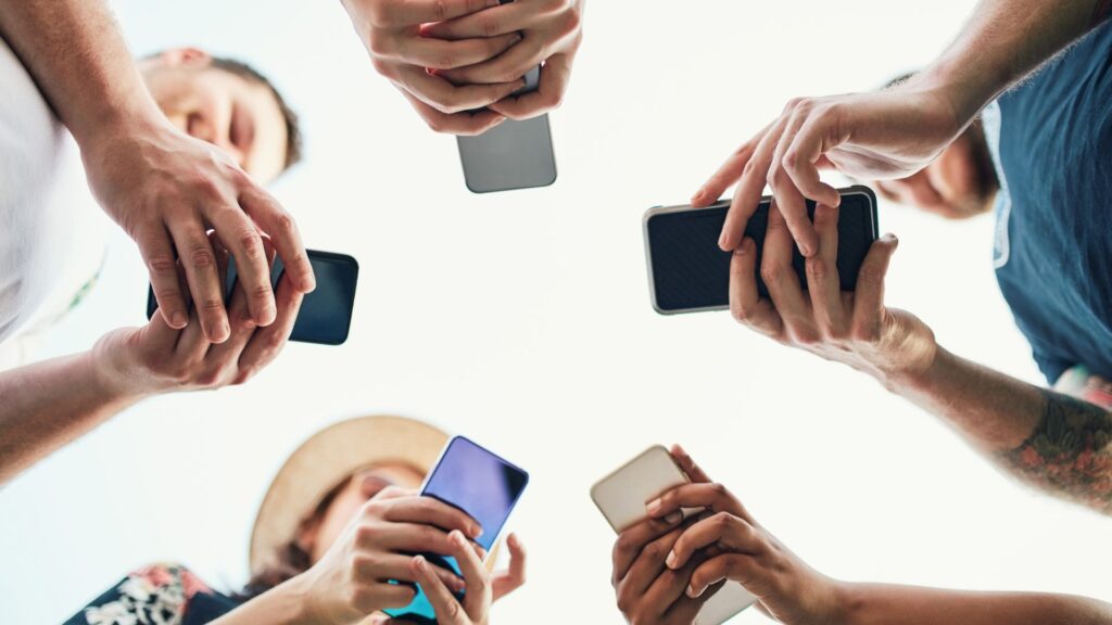 People standing in a circle with smartphones in their hands.