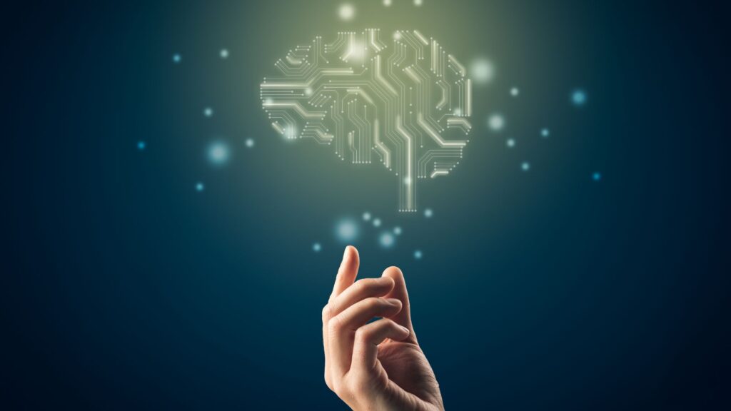 Hand reaching towards a digital representation of a human brain.