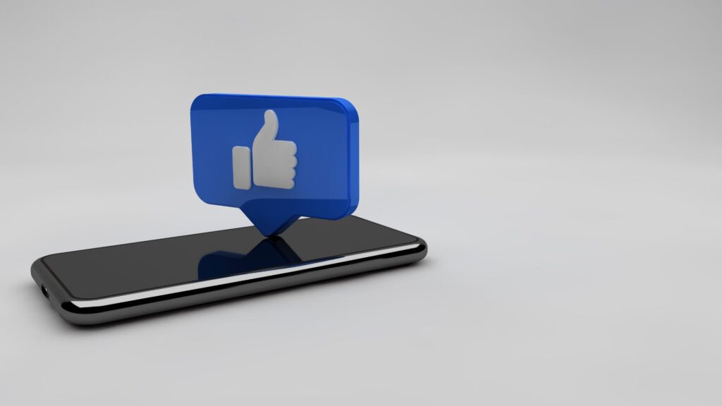 Smartphone lying down with a Facebook thumb above it.