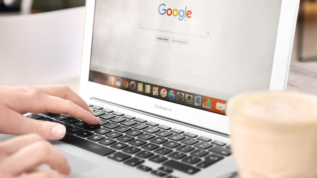 Hands on laptop with Google Chrome on the screen.