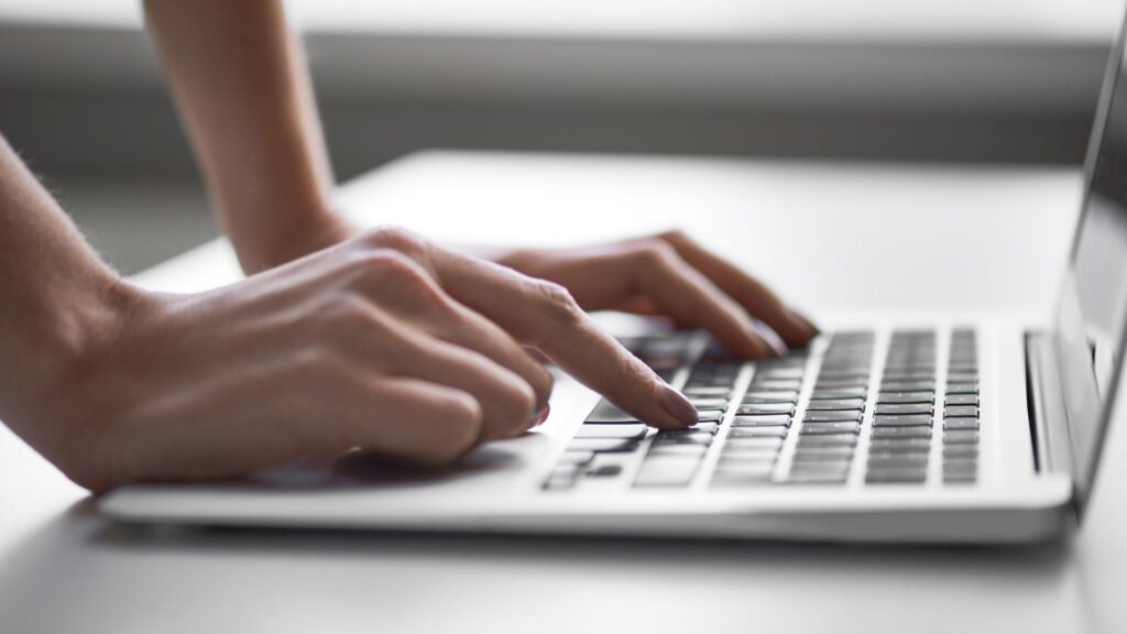 Hubspot user pressing laptop keyboard.