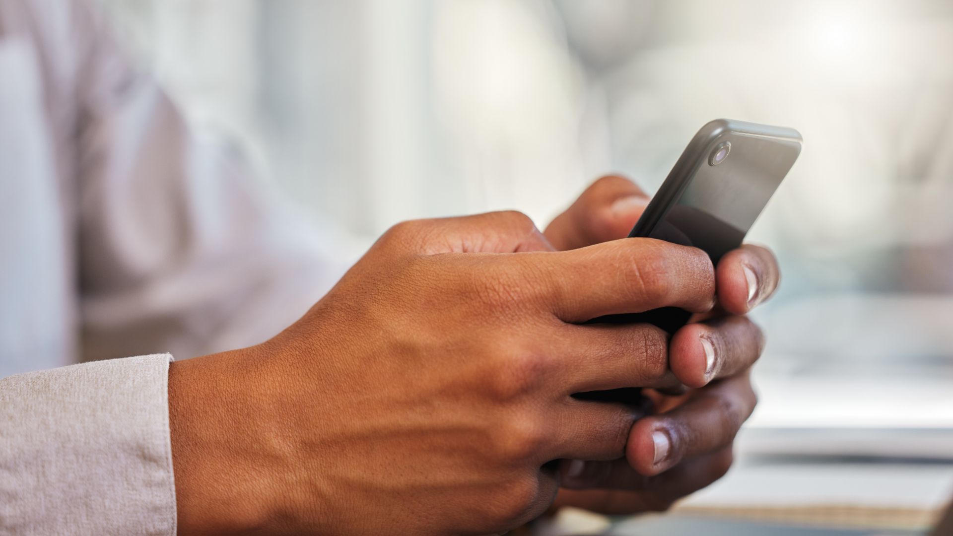 LinkedIn user holding black smartphone with both hands.