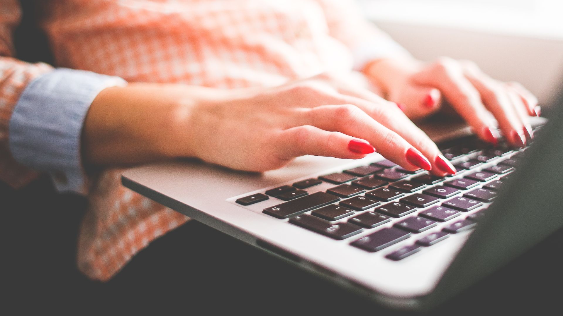 Person sitting by laptop visiting a popular website.