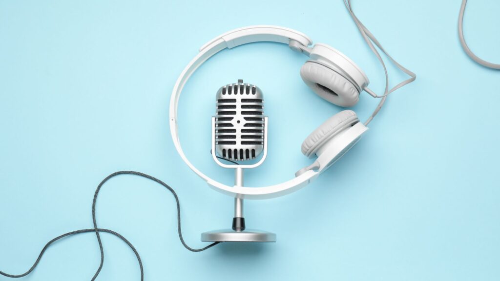 Podcast microphone and headphones on a blue background.