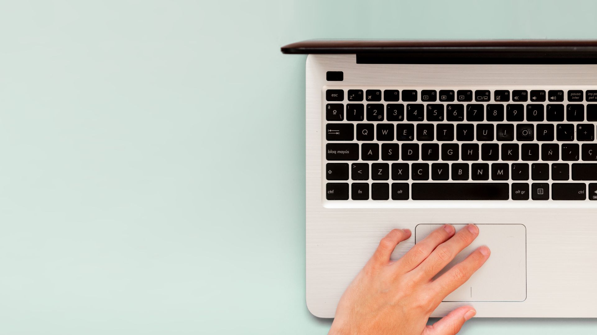 Hands on laptop keyboard practicing SEO copywriting captured from above.