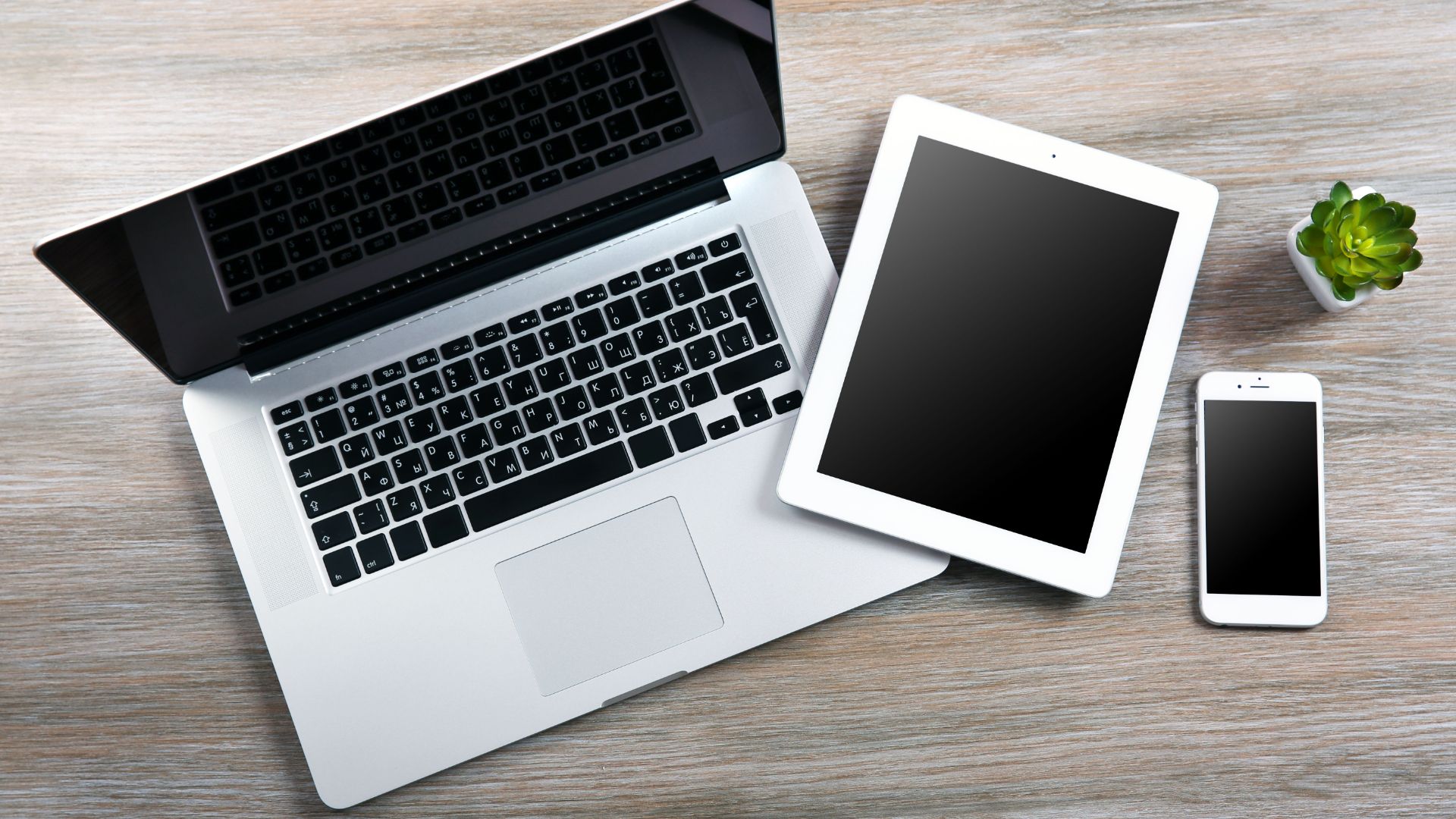 Laptop, tablet, and smartphone on table.