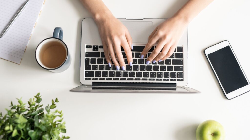 Substack user writing on laptop by a desk.