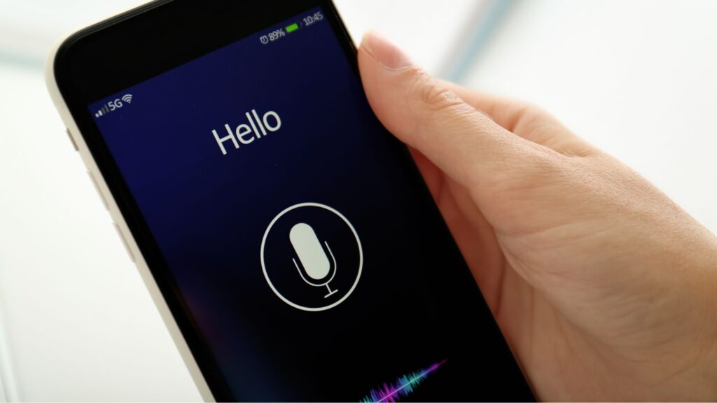 Hand holding smartphone in voice search mode.